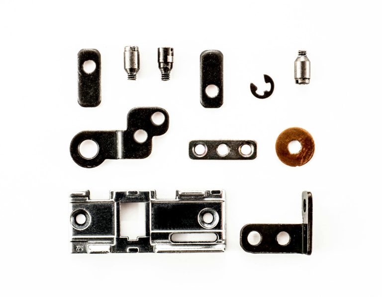 A top view of various metal fasteners arranged on a white background.